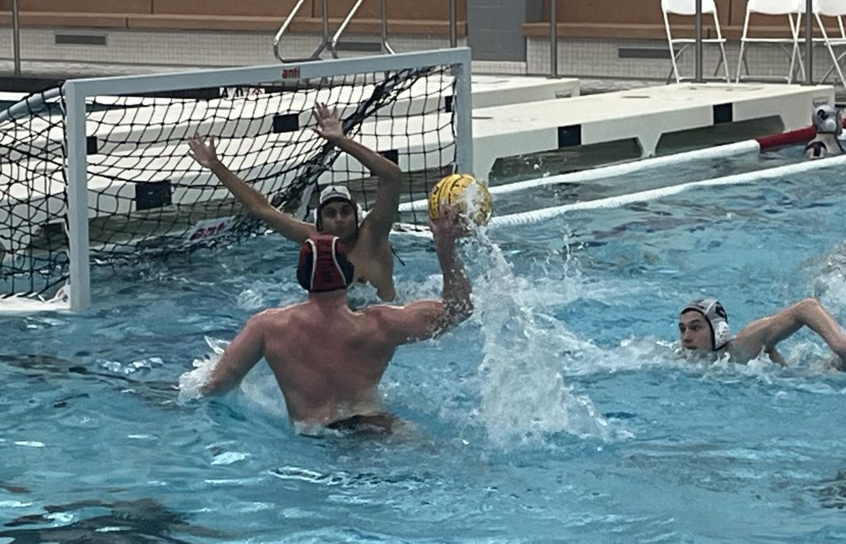 Senior Sam Rasin (5) springs into the air to shoot against Fremd goalie and senior Ansh Parikh (1). Rasin, also a varsity swimmer, successfully scored the goal, one of two he had during the second quarter. 