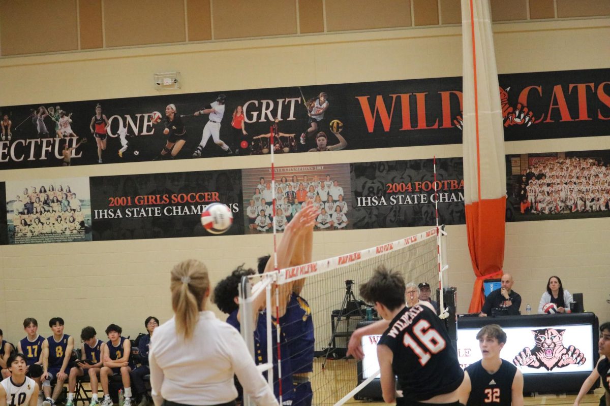 Sophomore outside hitter Connor Desiron (16) hits the ball past Glenbrook South’s  players in the second set.
