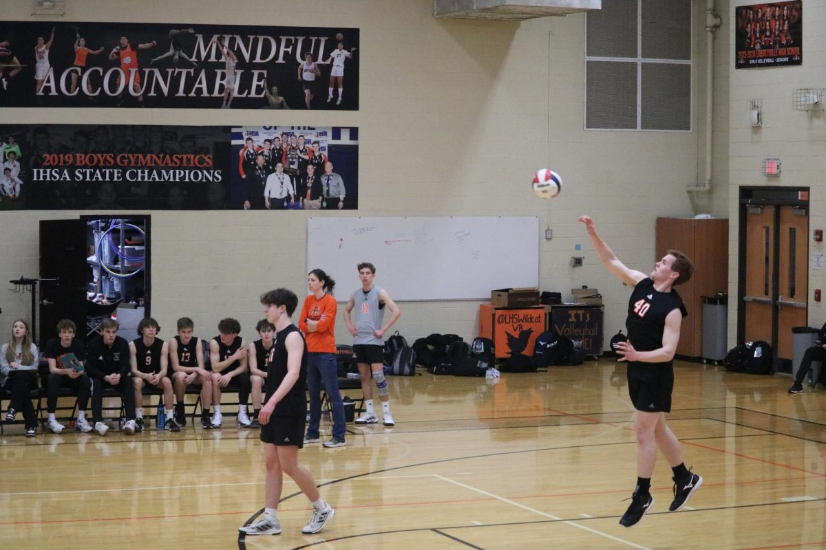 Junior middle blocker Jordan Coughlin (40) serves in the second set against Glenbrook South.