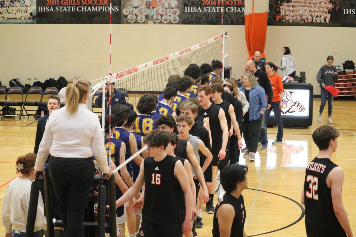 The Wildcats and Titans meet at the net to exchange handshakes at the end of the second set, which ended in a 25-19 loss for Libertyville.