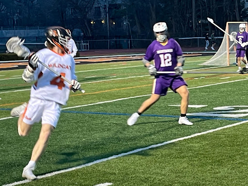 Senior Kyle Carollo (4) carries the ball on the sidelines near Rolling Meadows’ goal, guarded by Mustang and junior Peyton Wiles (12). Carollo, a team captain, scored twice in the game’s second quarter. “We just knew we had to come in and focus on us and that’s what we did,” Carollo said. “Everyone was scoring, all parts were moving and we did our job.”