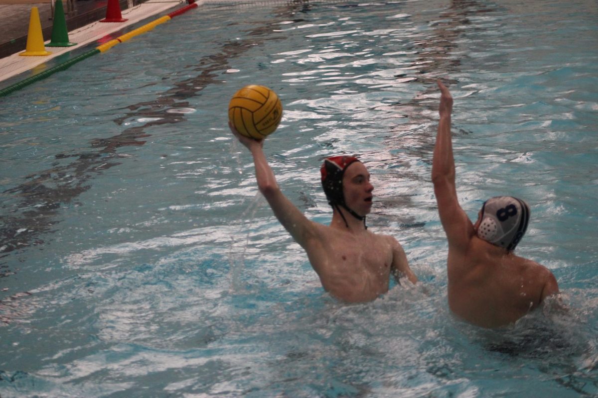 Junior Aaron Skarbek (6), guarded by Highland Park junior Brody Schultz (8), prepares to pass the ball to his teammates during a game against the Highland Park Giants. Skarbek is one of seven juniors on the team, several of whom played during the senior night game that saw a 13-6 Libertyville win.