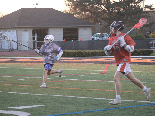 Senior attackman Tommy Gonnella (15) makes his way down the field as his Lake Zurich opponent, sophomore Ryan Hasemeyer (17), closes in. Gonnella has been on the varsity team since his sophomore year.