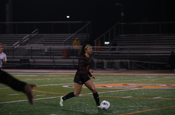 Freshman Lainey Chung (12) dribbles the ball down the field, searching for an opportunity to pass to a teammate.
