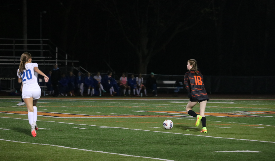 Sophomore Sydney Krukonis (18) swiftly passes opposing players as she brings the ball down the field.

