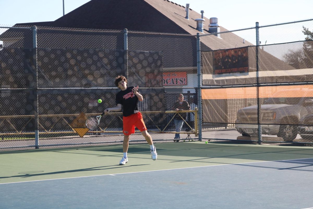 Freshman varsity member Chase Pierce returns a forehand volley during the first set of his singles game, winning the set 7-5. 