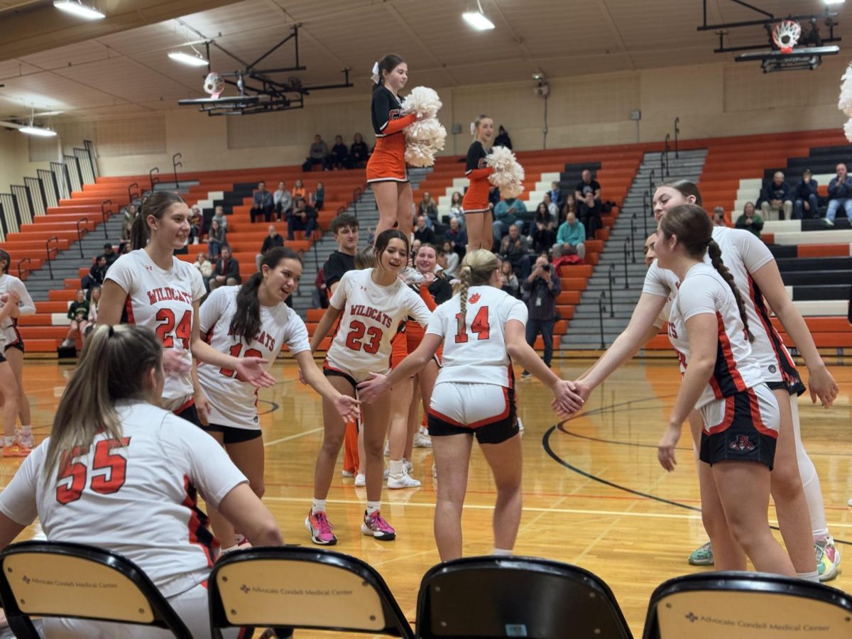 Senior Sophia Cesnovar (14) Sprints down the path of her supporting teammates. This is a game-day tradition where team members get introduced to the crowd individually and perform a special handshake with their teammates at the end of the line. At this event, sophomore Charlotte Harrison (4) stood at the end.