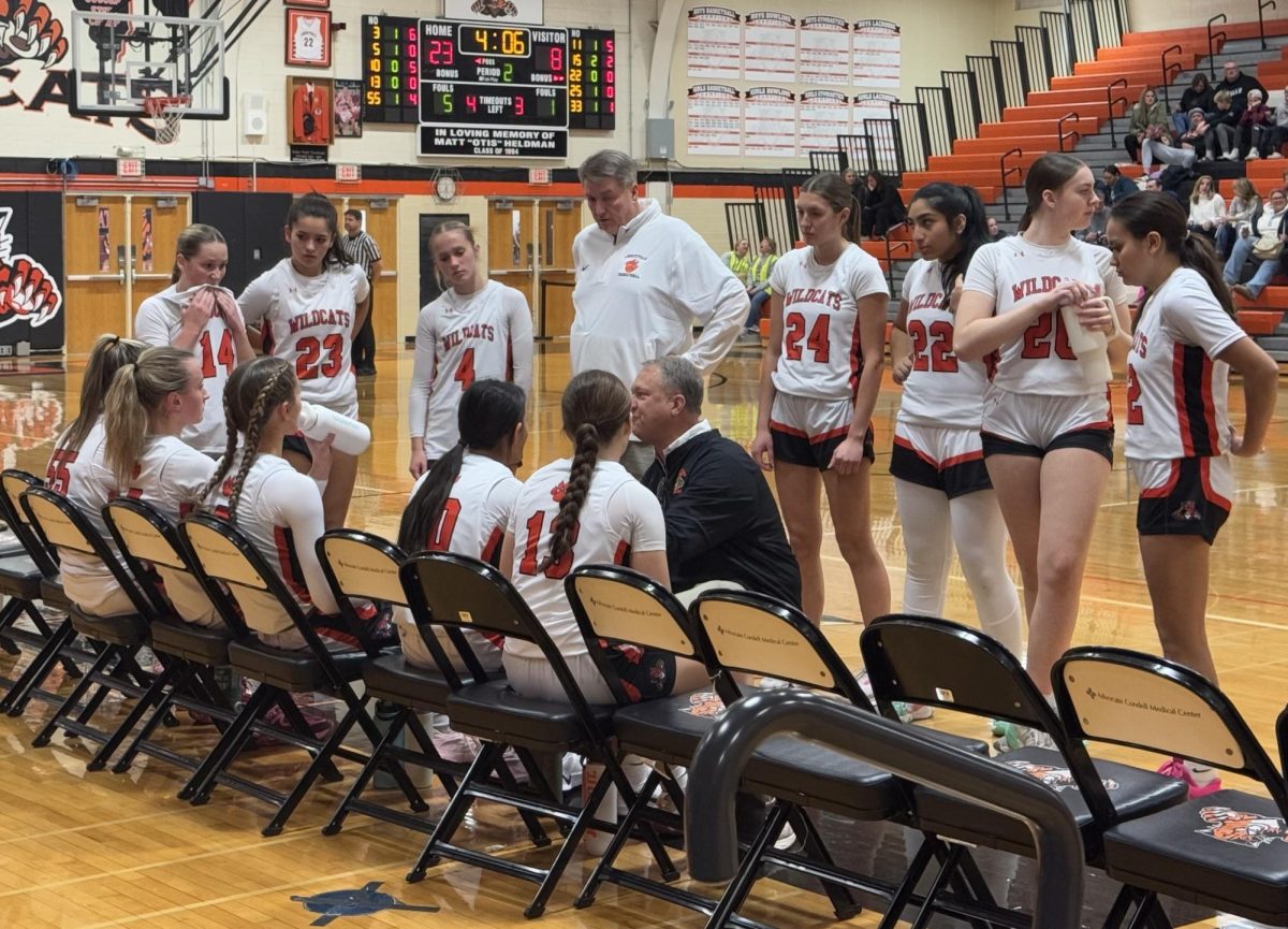 The Wildcats call a timeout during the second quarter to discuss strategies to improve their game and ways to avoid fouls. The Wildcats later won the game 52-25.