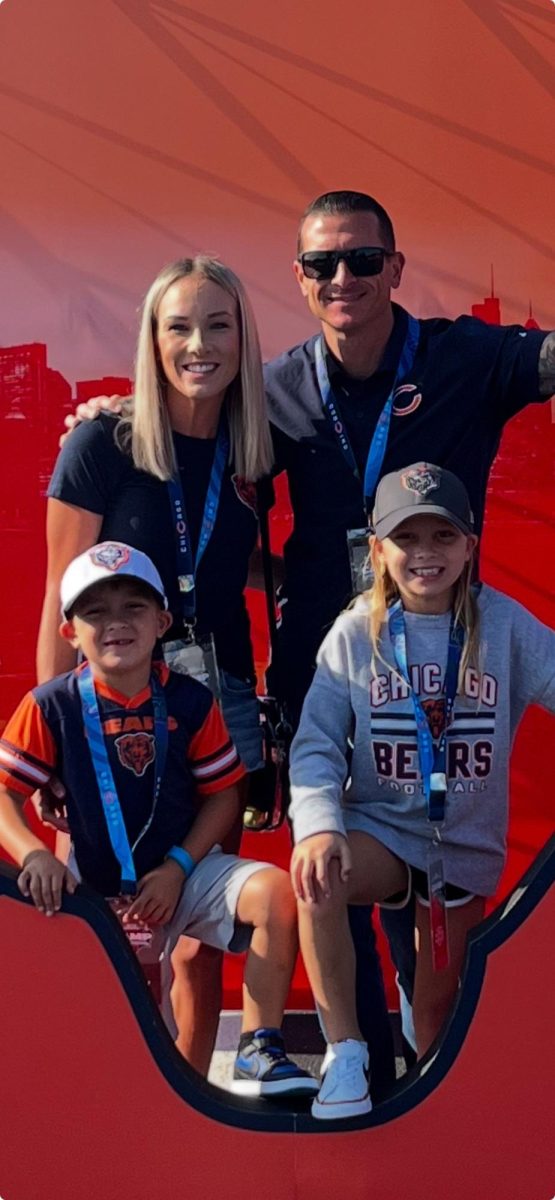 Mr. Eric Brzezinski poses for a photo with his wife and children at a Chicago Bears game. After graduating from LHS in 2008, he now works at ShurWay Moving, a family-owned moving and storage business here in Libertyville. “I think a lot of our teachers and being in Libertyville High School brought a lot of knowledge to the business development as well as the learning,” he said. (Photo courtesy of Mr. Eric Brzezinski)
