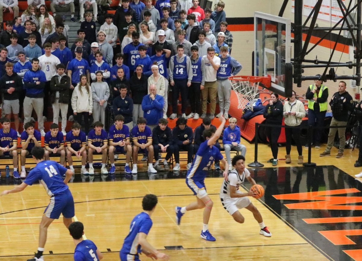 Freshman Terrence Davis (23) drives to the hoop against the Scouts’ Center Grant Mordini (2).