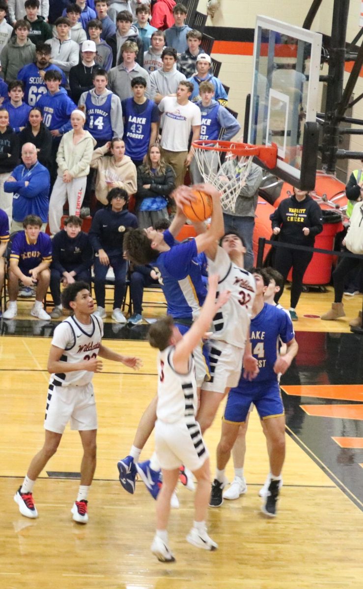 Junior Bryce Wegrzyn (32) fights for a rebound against Lake Forest Scouts’ Center Grant Mordini (2). 
