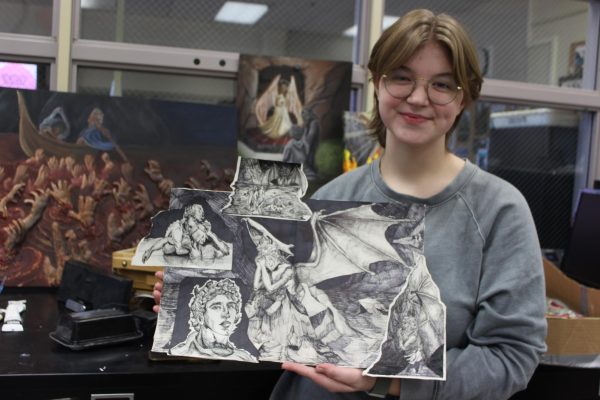 Senior Ava Koot stands beside her pen/ink drawing based on the trilogy of the book Dante’s Divine Comedy. This piece uses a comic-like style to show different scenes and emotions.
