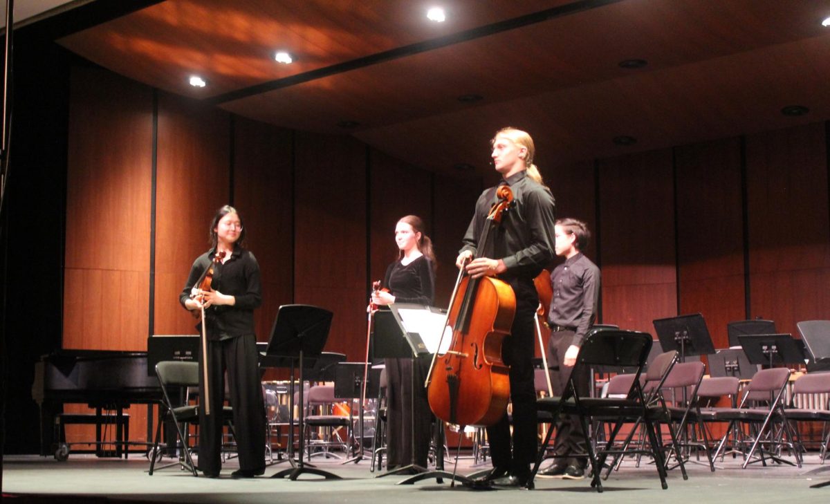 The String Quartet, made up of members from the higher-level Chamber Orchestra, stands to bow after their performance of the first movement of Maurice Ravel’s String Quartet. The piece features colorful textures and flurries of notes under a lyrical theme.