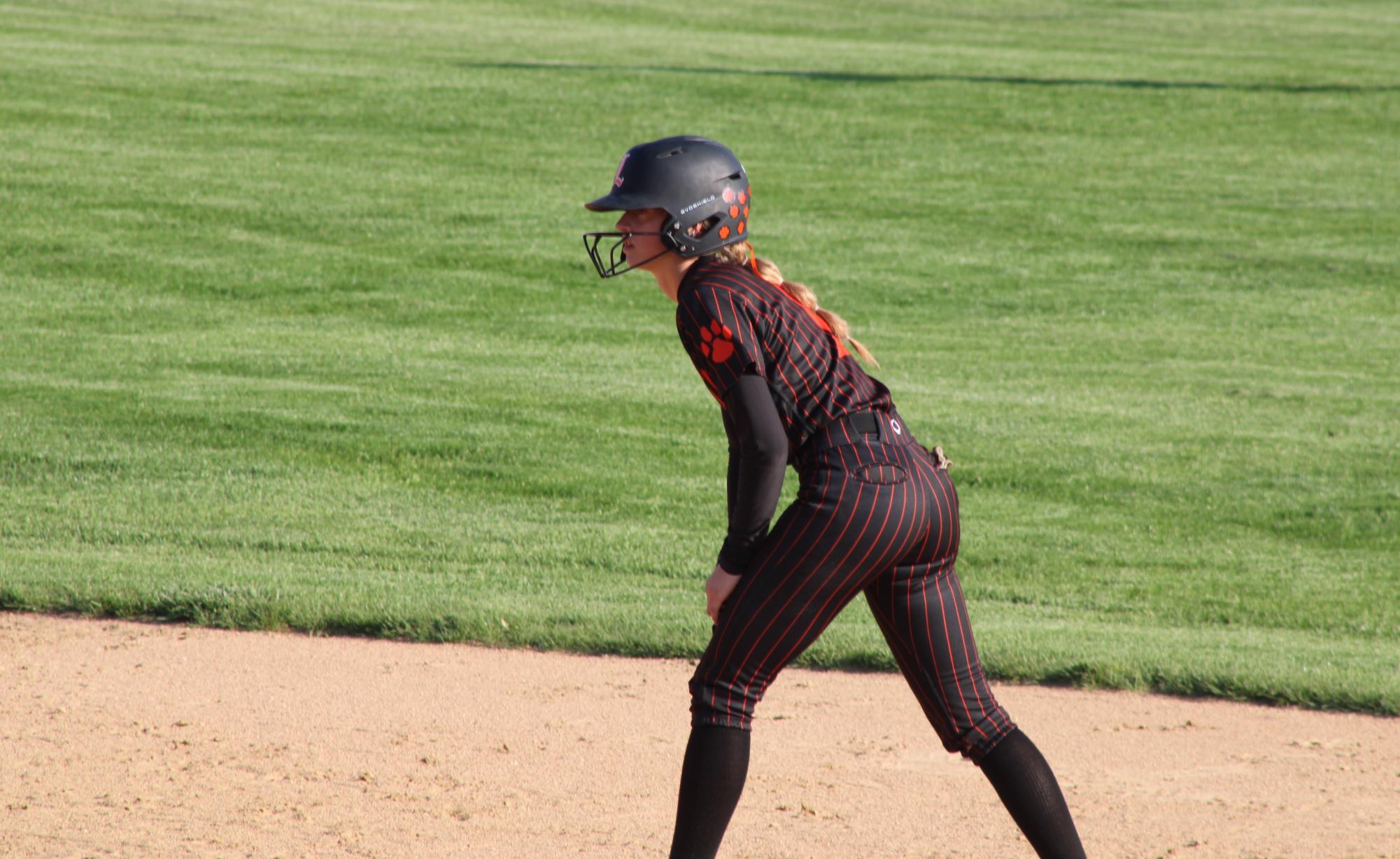 Junior Taylor Higham (1) waits on second base as her teammate takes on Mundelein's pitcher in a pivotal at bat. Higham is one of the teams' pitchers.