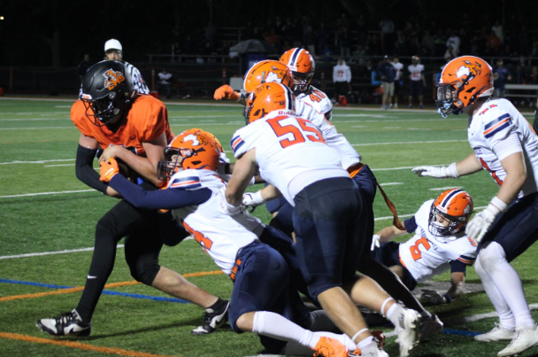 Senior quarterback Brady Buenik (10) forces his way through the Naperville North defense, showing his elite toughness and commitment to moving the ball no matter the challenge. “I told the guys their effort was unquestioned. I mean, they battled all night,” Head Coach Tim Budge said.
