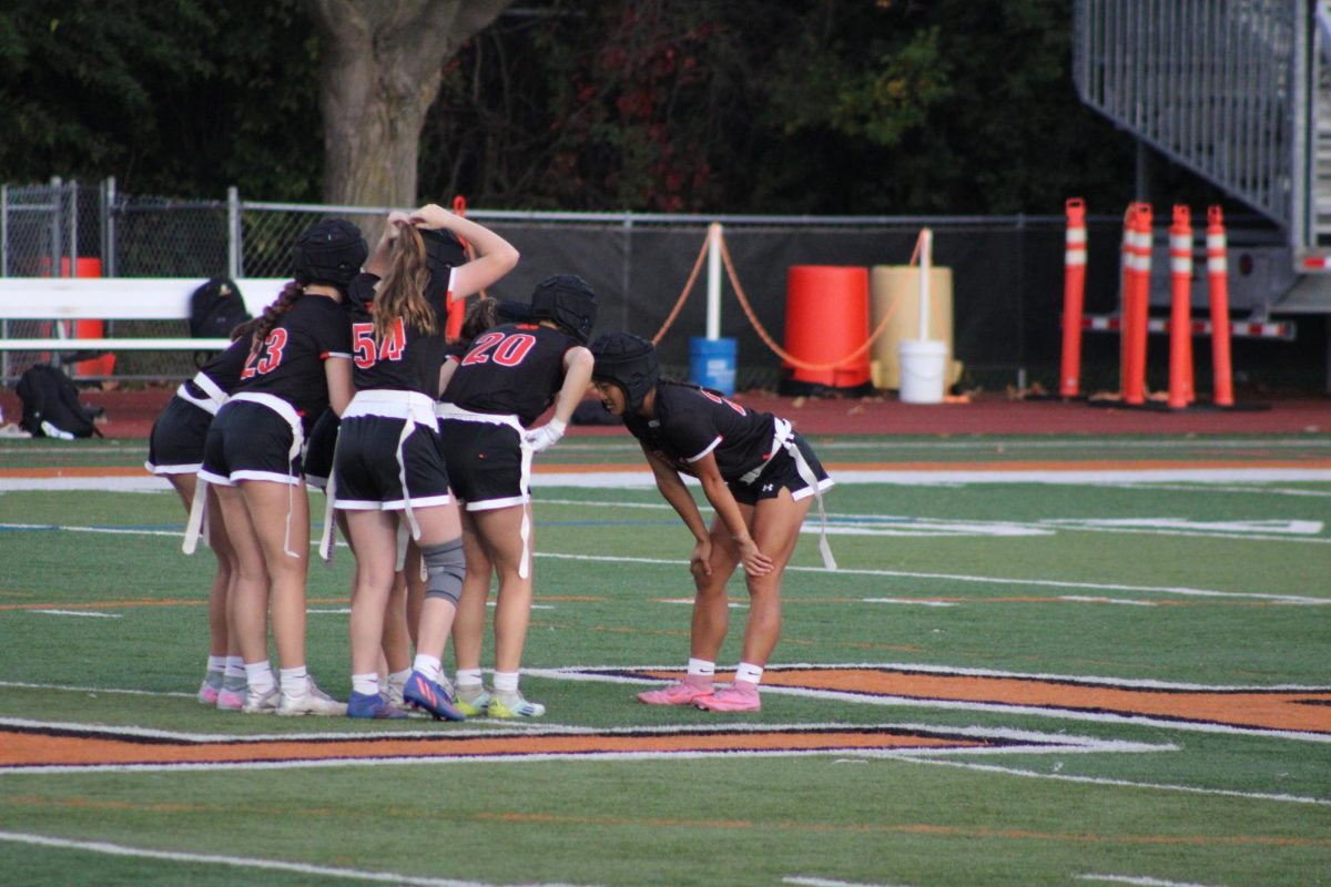 Libertyville varsity quarterback Sophia Swanson leads a huddle. On Sept. 16, the Wildcats secured a 42-6 win over Glenbrook North.