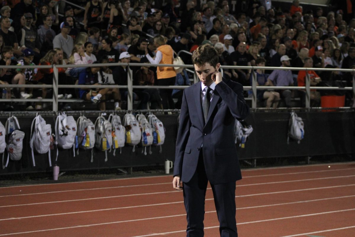 During the first televised game on LHS's home turf, sideline reporter senior Ryder Allen waits for the game to start. "It's sort of like we have that deeper insight into the game, and it's just a very useful skill to have and a useful thing to be able to do for the broadcast," Allen said about his role.