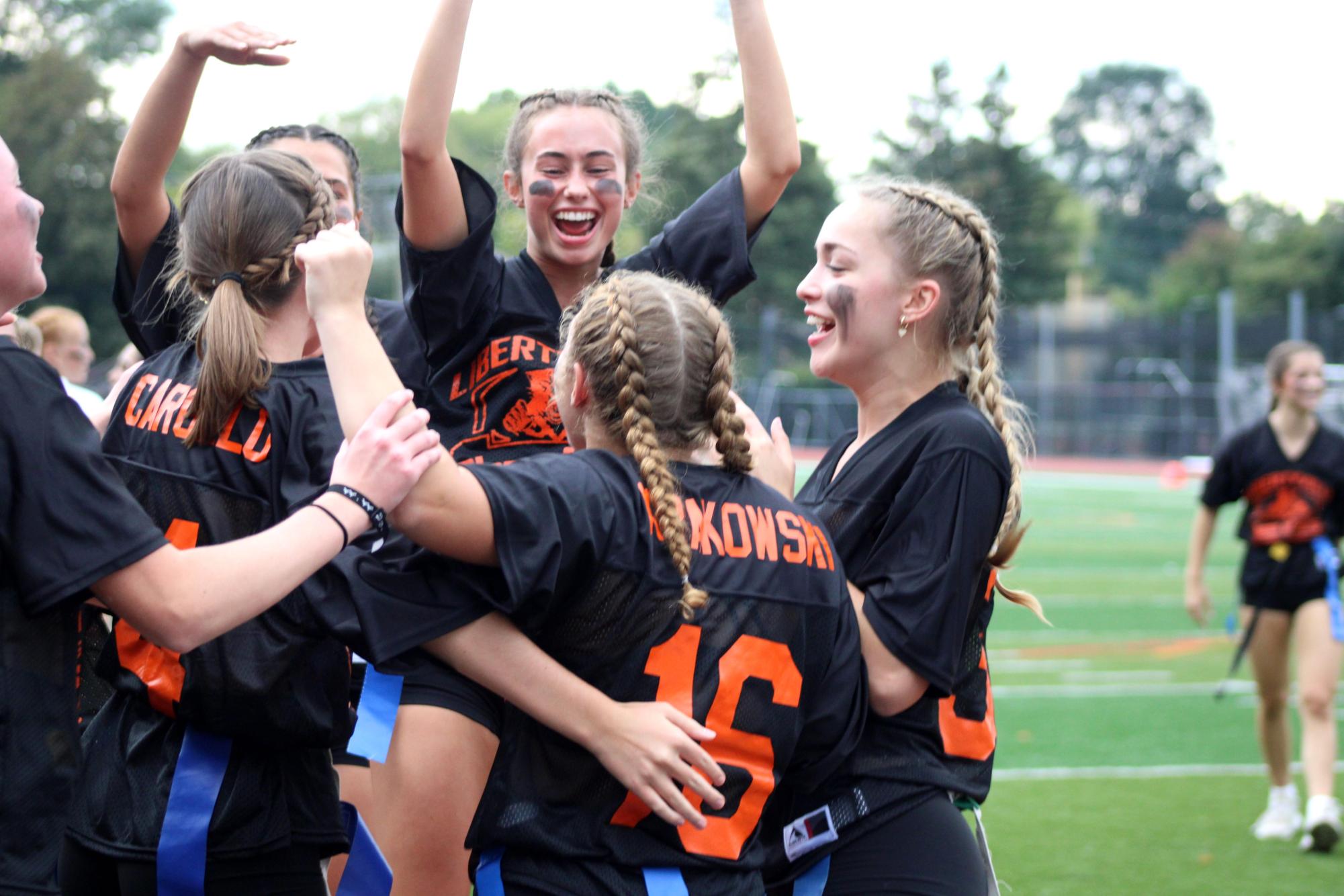 Players of the third quarter black team celebrate after a touchdown by senior Shea Krakowski. Krakowski shined as a player helping the team to a victory despite being called off mid-game due to storms.