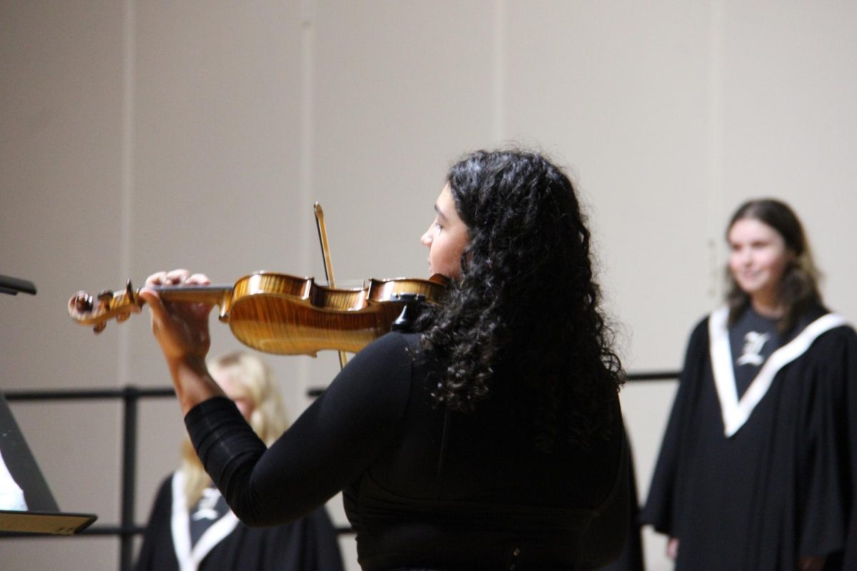 Senior orchestra member Eva Thomas showcases her abilities by playing the violin along to Bel Canto’s performance of “The World is Full of Poetry” by David Brunner. Thomas is also a part of the Concert Choir. She was also part of the all-state choir last year.
