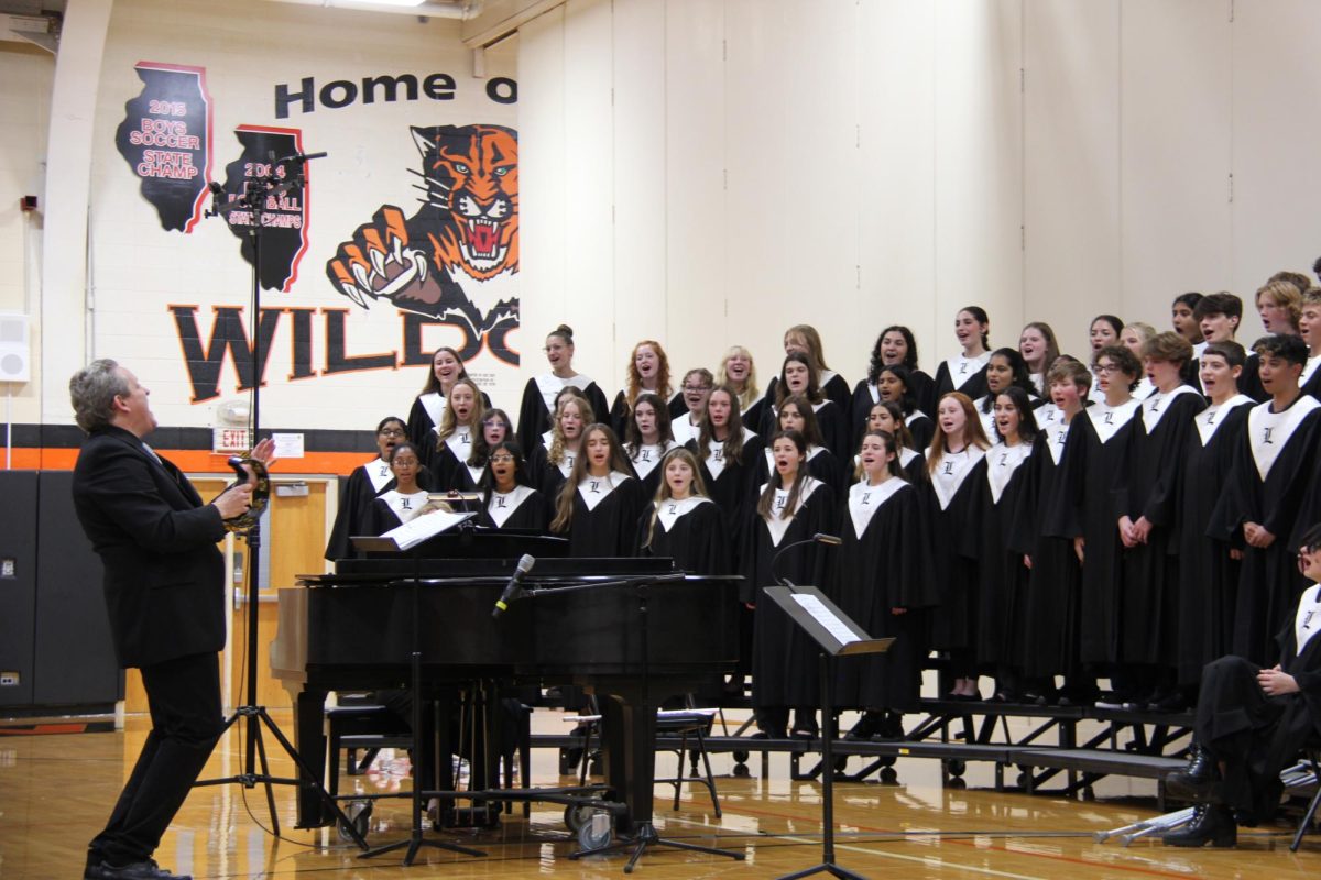 Choir director of 25 years, Dr. Jeff Brown, plays the tambourine while they sing “Sing a Song” by Earth, Wind & Fire. For the performance of this song, a band played along with the choir. The band consisted of Adam Gorh, Matt Karnstedt, seniors Richie Dombrowski, Thomas Texiera and sophomore Vince Lombardo.


