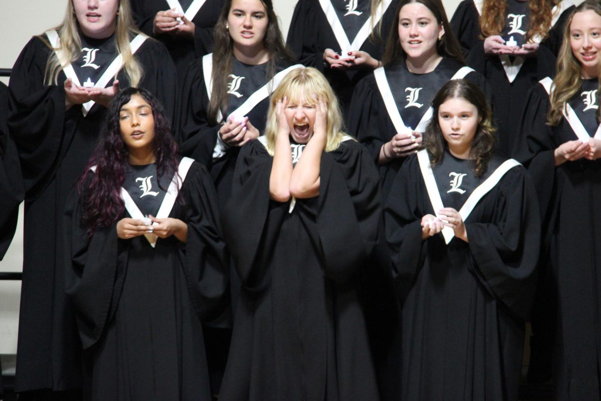 Bel Canto member, junior Savannah Agee, surprises the audience with a scream in the middle of the choir’s performance of “An Awful Tempest” Arr. Jefrey Cobb. This song was the only one of the night that was performed with the lights dimmed. The choir held candles to help with the lighting.
