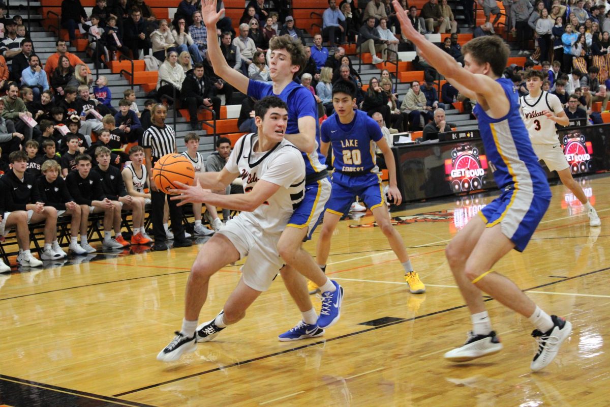LHS boys' varsity basketball forward, Bryce Wegrzyn (32), evades multiple Lake Forest players to get to the basket. Recently, Wegrzyn signed to Winona State University to continue his basketball career as a D2 prospect.