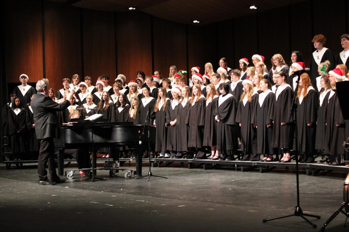 Following the reverent candlelight procession, the combined Holiday Festival Choir sings a medley of holiday tunes titled "Holiday Road of Carols" by Greg Gilpin