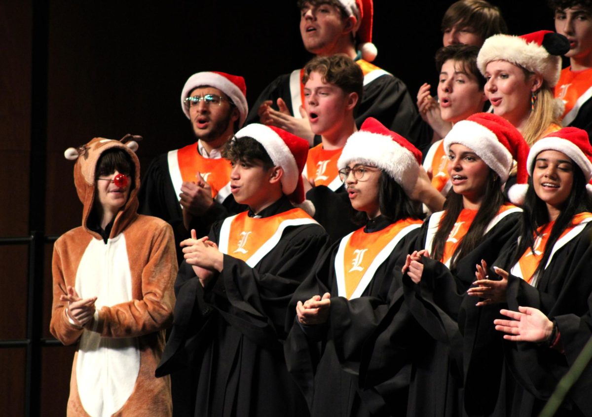 Senior John Zidek of the Concert Choir entertains the audience with his Rudolph the Reindeer costume. During "Run Run Rudolph" by Kirby Shaw, Zidek sped through the aisles of the audience, giving them an entertaining moment.
