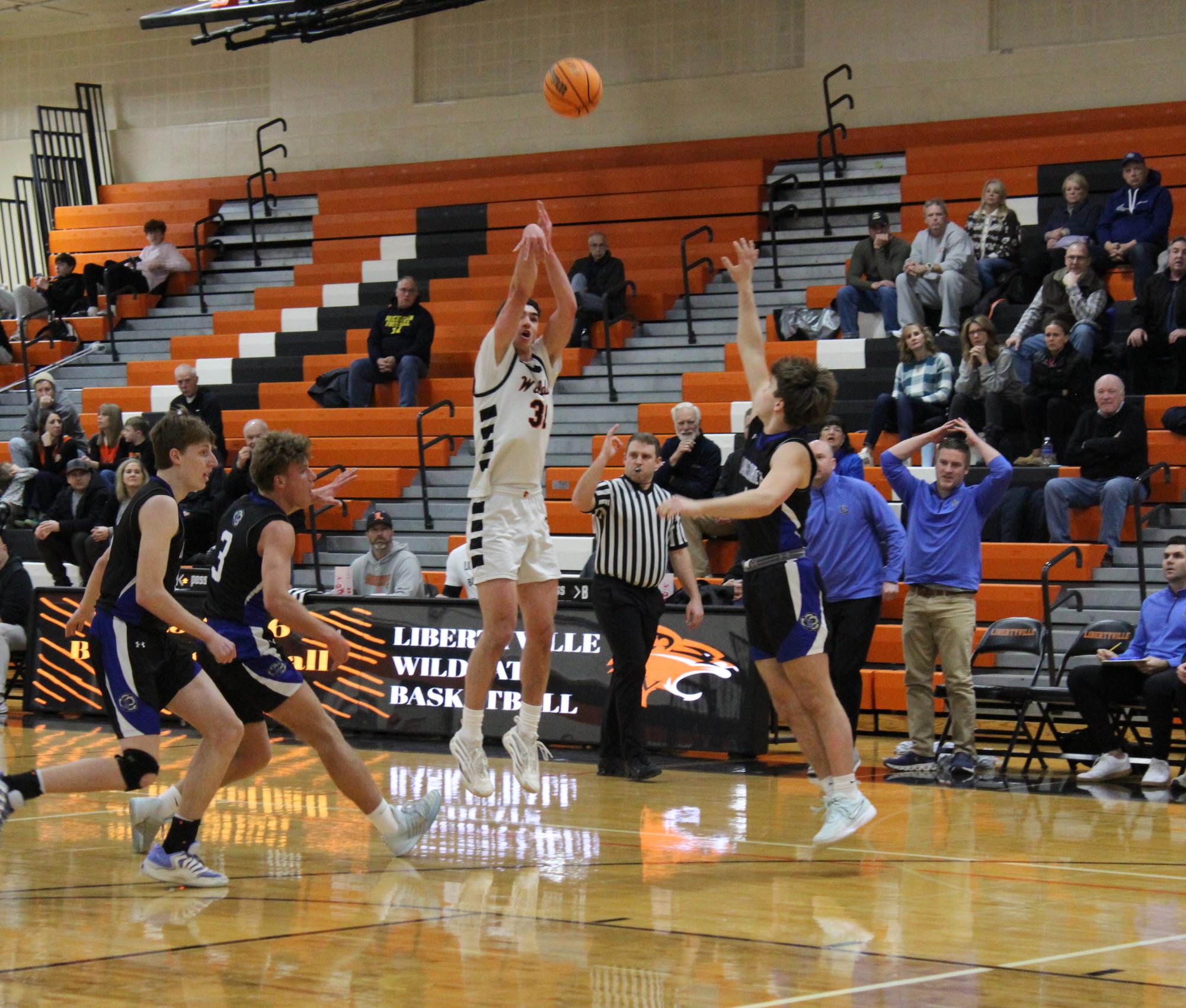 Senior Bryce Wegryzn (32) goes up for a jump shot, with Lake Zurich player senior Reid Pfeifer (4) quickly trying to block. While Wegryzn didn’t make it, this set up the Wildcats in a 7-6 tight lead. 