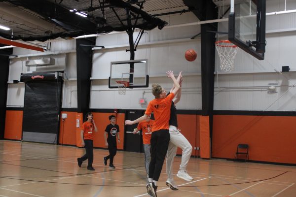 Students compete in a basketball tournament during Lifetime Sports and Fitness, an LHS PE class. They wear the required orange or black school-issued uniforms, another department policy.