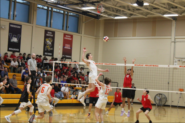 Senior middle hitter Nathan Knight (0) jumps up for a kill against Mustang Senior Andrew Jimenez (13).