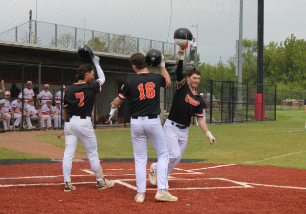 Junior Madden Cotts (7), senior Braden Tolzien (16) and senior Jack Cenar (25) celebrate Cenar's home run to right field, which helped the Cats tie the game 2-2 in the top of the second inning.